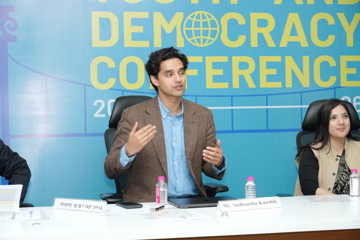Sudhanshu Kaushik speaking on a panel at a democracy conference